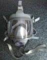 This is a 'refurbished' mask, using new outer and inner mask, neck strap, harness and polycarbonate visor. Its assembly may contain a recovered port manifold (not distinguishable from new) and manifold banding is 316 stainless steel, each assembly tested in excess of EN250/136 tension requirements (250N).